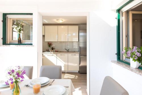 Una cocina y un comedor con mesa y sillas. en House Mari, en Punat