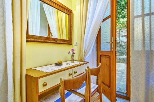 a dresser with a mirror and two chairs in a room at Apartments Old Sailor s House in Mali Lošinj