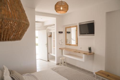 a bedroom with a bed and a tv on the wall at Christiana Hotel in Ambelas
