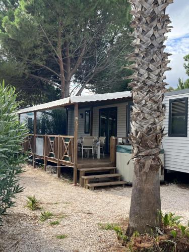 Cette petite maison dispose d'une terrasse couverte et d'une table. dans l'établissement Camping Del Mar 265, Mobile Home Excellence, 3 chambres, 6 personnes, 2 Salles de Bain, bord de mer, à Argelès-sur-Mer