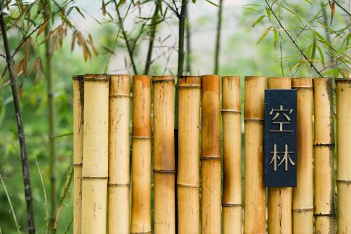 a bamboo fence with a sign on it at 大山初里 Origin Villa Village Hotel&Resort in Tonglu