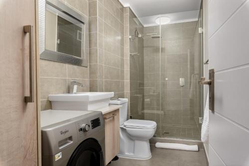 a bathroom with a toilet and a sink and a shower at Waters Edge Apartments in Cape Town
