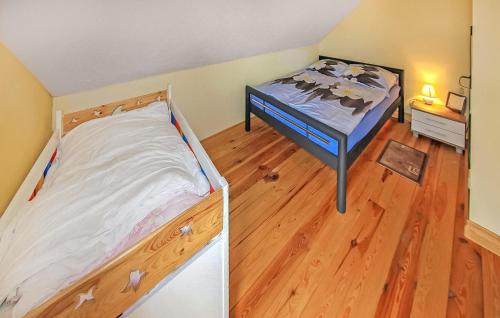 a bedroom with a bed and a wooden floor at Ferienhaus Funkenhagen in Funkenhagen
