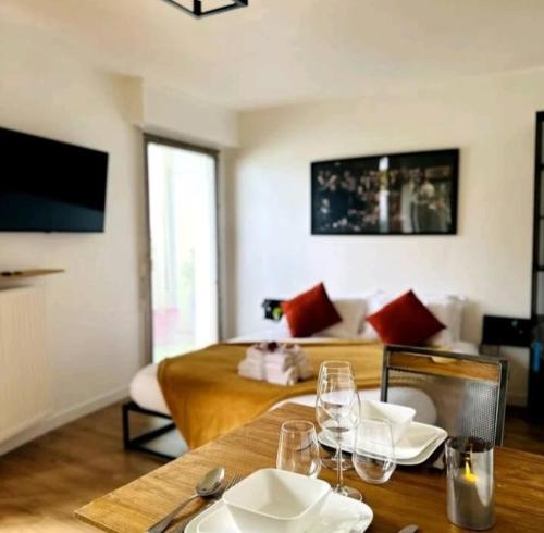 a living room with a table with wine glasses on it at Le Golden-Terrasse & Parking in Rennes