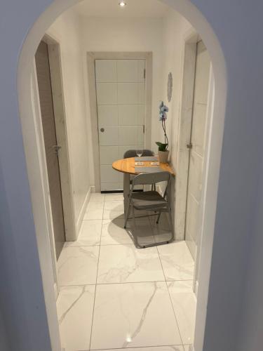 a hallway with a table and a chair in a room at Luxury studio apartment, Beckenham in Elmers End