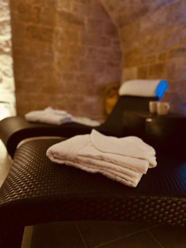 a group of towels sitting on a bed at Un giorno bellissimo suite & spa in Martina Franca