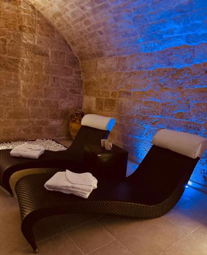 two beds in a room with a brick wall at Un giorno bellissimo suite & spa in Martina Franca