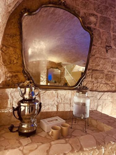 a mirror sitting on top of a counter with cups at Un giorno bellissimo suite & spa in Martina Franca