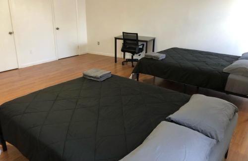 a bedroom with two beds and a desk with a chair at Large and private apartment that sleeps up to 10 people comfortably with direct NYC Manhattan train only 5 minute walk away in Elizabeth