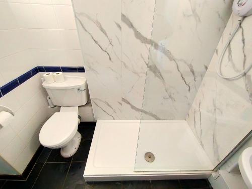 ペンザンスにあるThe Long Barn for Families Walker Pets & Workersのトイレとシャワー付きの白いバスルーム