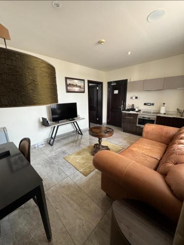 a living room with a couch and a kitchen at The Palms by Eagles Accra in Accra