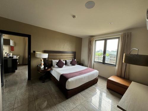 a hotel room with a bed and a window at The Palms by Eagles Accra in Accra