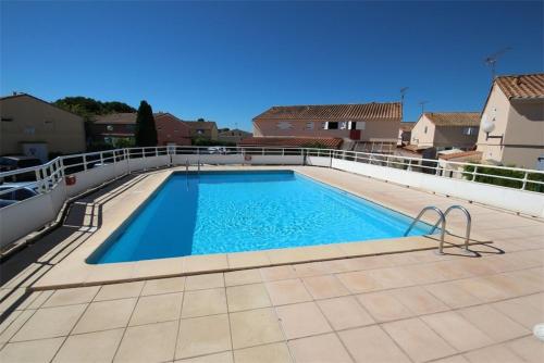 une grande piscine sur le toit d'une maison dans l'établissement Maison T2 cabine 4 couchages, terrasse cloturée, résidence Sun village avec piscine commune, 300m de la plage à PORTIRAGNES PLAGE LRSUNR6, à Portiragnes