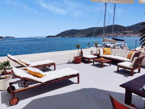 a deck with couches and chairs on a boat at Waterfront House Carolina in Vis