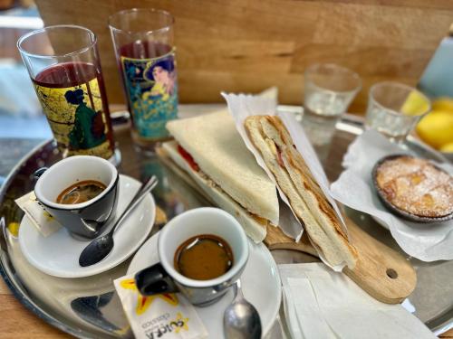 罗马Eterna Suites Roma的一张桌子,上面放着两杯咖啡和一盘食物