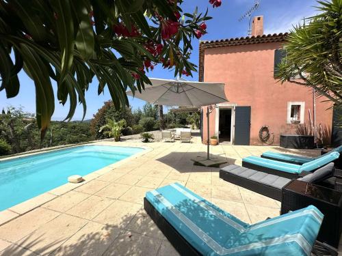 une piscine avec des chaises et un parasol à côté d'une maison dans l'établissement Villa Paloma pour 6 personnes avec piscine privée, à deux pas du Golf de Valcros, à La Londe-Les-Maures, à La Londe-les-Maures