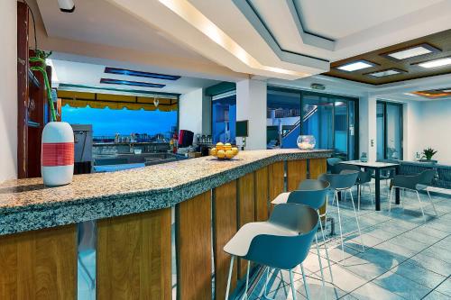 a lobby with a bar with chairs and tables at Bella Vista Hotel "by Checkin" in Hersonissos