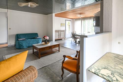 un salon avec un canapé et une table dans l'établissement Gîte La Bell'Angerie - Avec terrasse, à Hubert-Folie