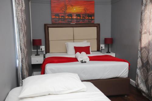 a bedroom with two beds with a stuffed animal on them at Kingsworth inn Port Elizabeth in Port Elizabeth