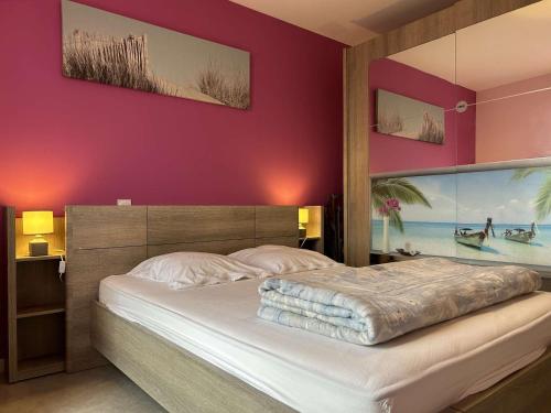 une chambre avec un grand lit aux murs violets dans l'établissement Appartement 2 pièces avec balcon, parking et proche plage à Saint-Gilles-Croix-de-Vie - FR-1-224-587, à Saint-Gilles-Croix-de-Vie