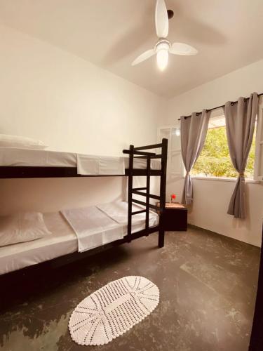 a bedroom with two bunk beds and a ceiling fan at Adios Amigos Hostel in Arraial d'Ajuda