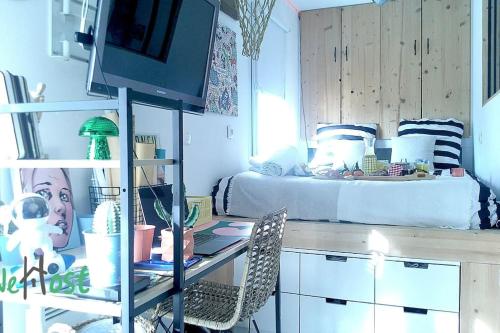 une chambre avec un lit et un bureau avec un ordinateur dans l'établissement Basse chenaie Cocon avec terrasse et Parking, à Nantes