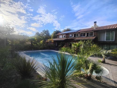 une maison avec une piscine devant une maison dans l'établissement La Grange Océane - Climatisation & Piscine Chauffée en saison, à Lège-Cap-Ferret
