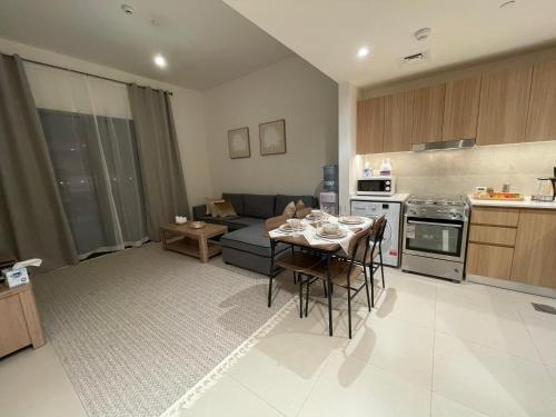 Una cocina y una sala de estar con una mesa y un sofá. en Cozy zone, en Sharjah