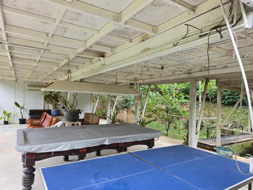 a mattress on a ping pong table in a patio at PapaVacay สวนผึ้ง in Ratchaburi