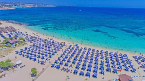 an aerial view of a beach with umbrellas and the ocean at The HEALTHY Stay-Padel, Pool&Fitness in Ayia Napa