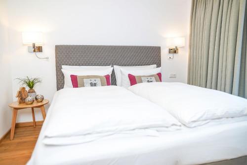 a bedroom with a large white bed with pillows at Simon´s Ferienwohnungen in Kurort Oberwiesenthal