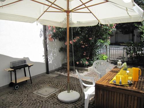 a table with an umbrella on a patio at Appartamento Pineta in Grado
