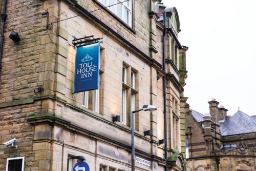 a building with a blue sign on the side of it at Toll House Inn in Lancaster