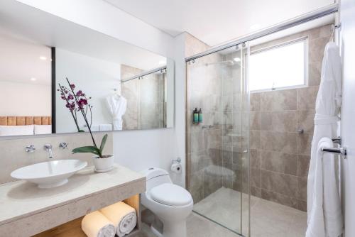 a bathroom with a toilet and a sink and a shower at Hotel Jazz Apartments in Bogotá
