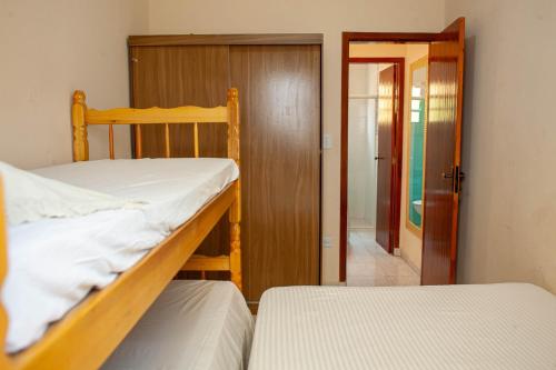 a bedroom with two bunk beds and a door to a hallway at Casa aconchegante c churrasqueira a 400m da praia in Samaritá