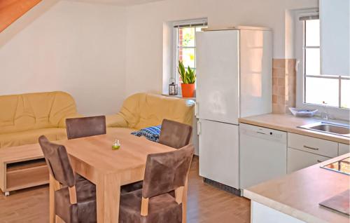 a kitchen and living room with a table and a refrigerator at Ferienwohnung Feldberger in Conow