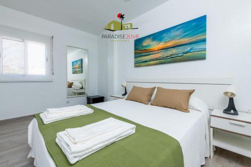 a bedroom with a bed with towels on it at Casa Alubsan in Puerto del Rosario