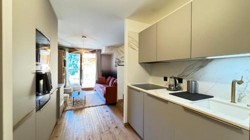 une cuisine avec un évier et un plan de travail dans l'établissement Appartement cosy à l'Ariondaz, à Courchevel