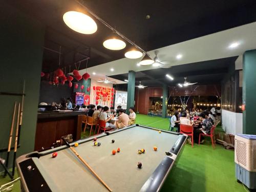 a ping pong table in a restaurant with people eating at King Bavi Resort in Ba Vì