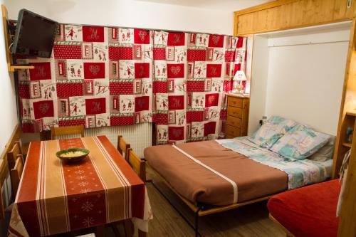 une chambre avec un lit et une table dedans dans l'établissement Les MENUIRES la Croisette Appt 6 pers Coeur de station, aux Menuires