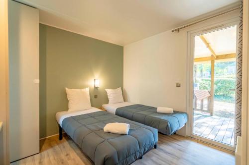 Кровать или кровати в номере Camping 4 étoiles Les Fougères