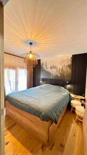 une chambre avec un lit et un lustre dans l'établissement Appartement cosy à l'Ariondaz, à Courchevel