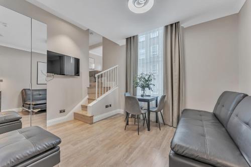 a living room with a couch and a table at Cleveland Residences Paddington in London
