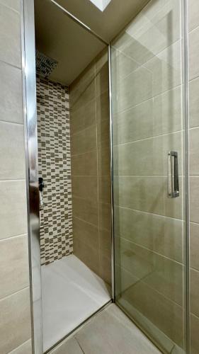 une douche avec une porte vitrée dans une salle de bain dans l'établissement Appartement cosy à l'Ariondaz, à Courchevel