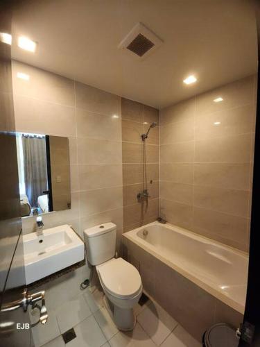 a bathroom with a white toilet and a bath tub at C1-7G Executive Studio with pool , 8boulevard Mactan Newtown in Lapu Lapu City