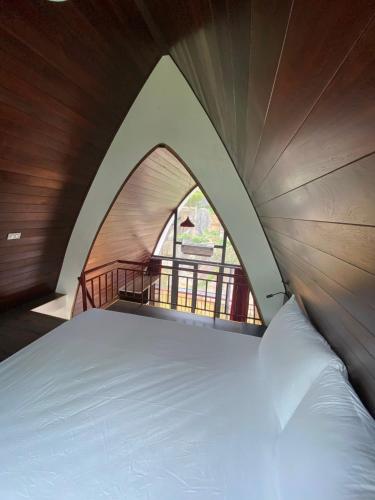 a large bed in a tent with a window at King Bavi Resort in Ba Vì