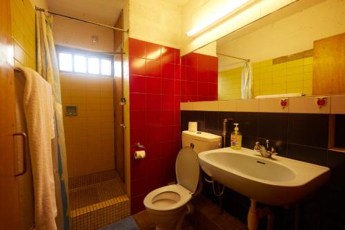 a bathroom with a toilet and a sink and a mirror at Villa Rock Stop Falls Gigiri in Nairobi