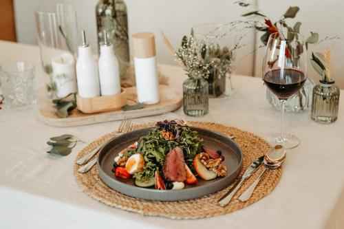 a plate of food on a table with a glass of wine at Löckerwirt in Sankt Margarethen im Lungau