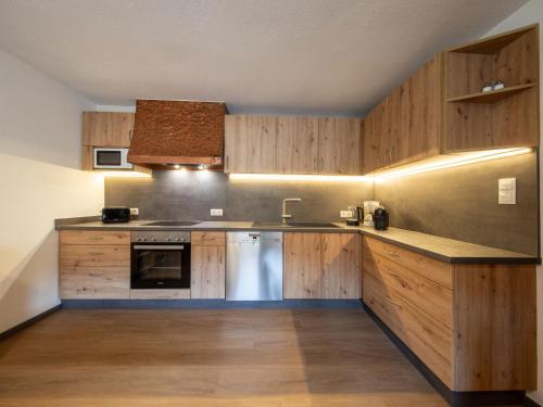 kuchnia z drewnianymi szafkami, zlewem i zmywarką do naczyń w obiekcie Holiday Home Kleewein by Interhome w Solden