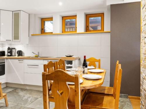 une cuisine avec une table et des chaises en bois dans l'établissement Apartment Fer à Cheval-1 by Interhome, à Châtel